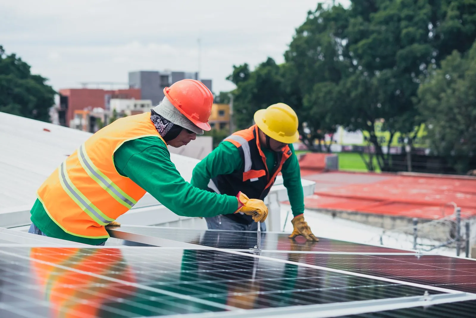 Echipă de montaj panouri fotovoltaice lucrând pe acoperișul unei clădiri comerciale