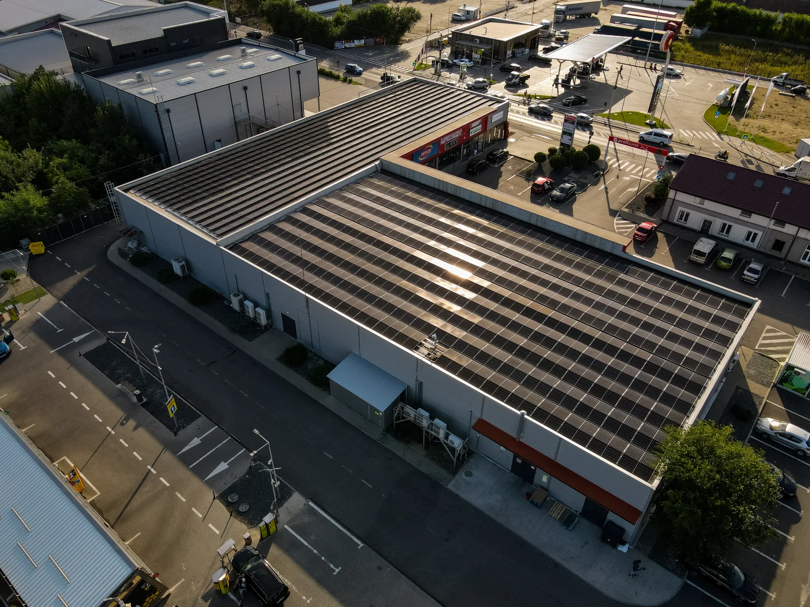 Sistem fotovoltaic industrial montat pe acoperișul unui magazin, cu rânduri de panouri pe toată suprafața