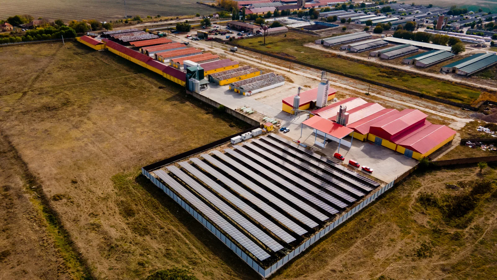 Vedere aeriană a sistemului fotovoltaic de 800 kW de la Grăbaț, montat la sol lângă halele beneficiarului