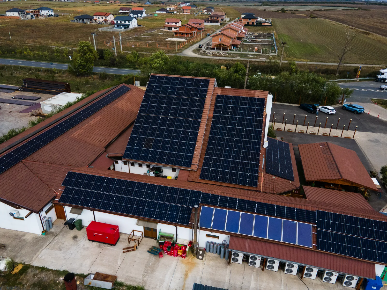 Vedere aeriană a unei pensiuni din Săcălaz cu panouri fotovoltaice montate pe mai multe planuri de acoperiș